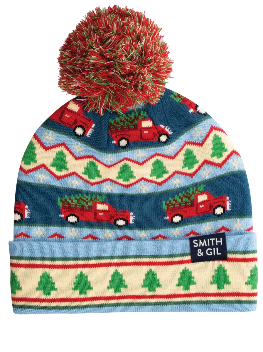 A beanie with a colorful pattern featuring red trucks and Christmas trees, topped with a multicolored pom-pom.