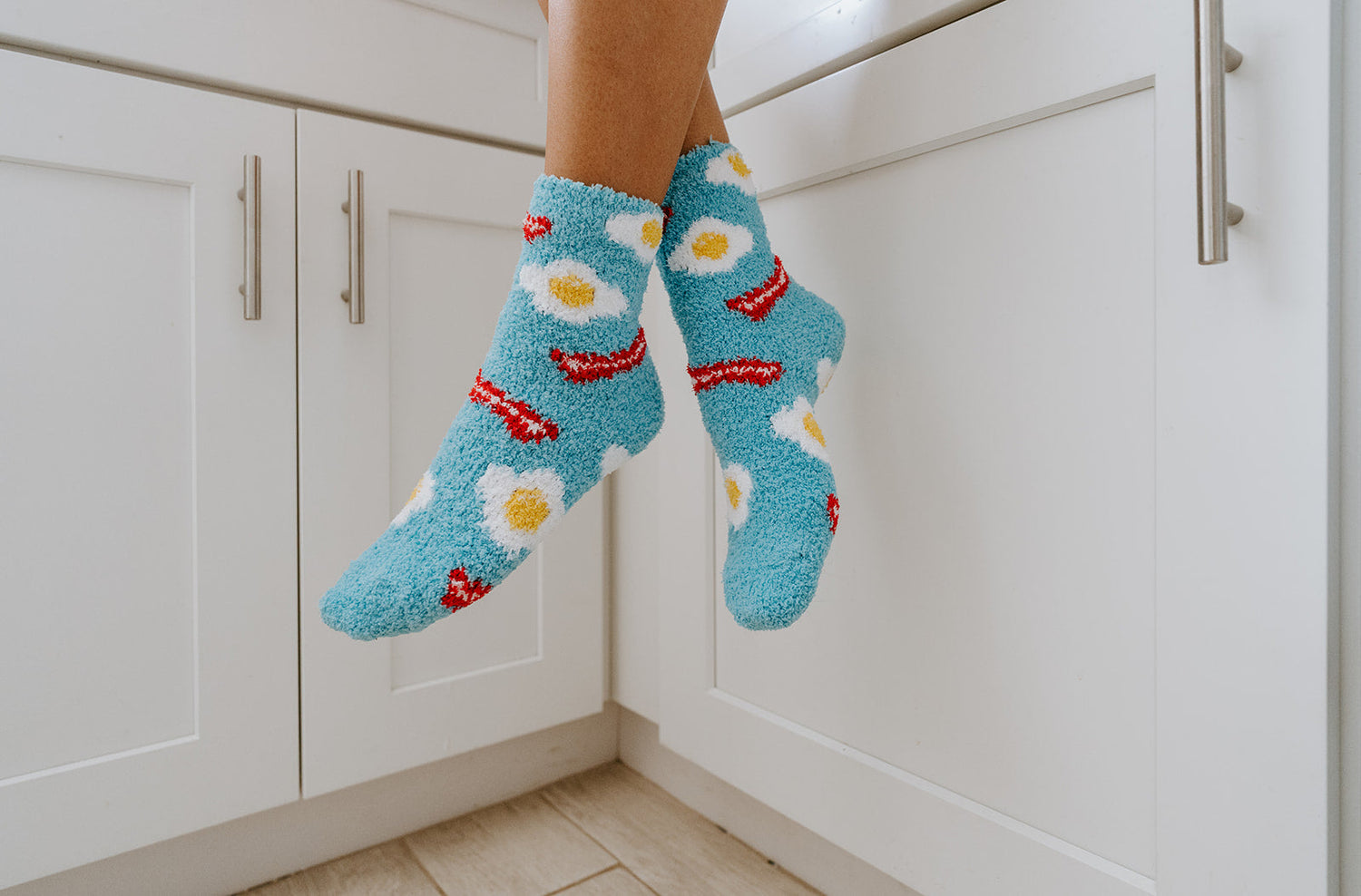 Wamr and Cozy socks featuring an eggs and bacon pattern on a blue background