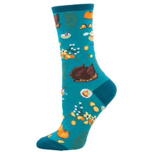 A pair of women's crew socks with a Thanksgiving theme, featuring illustrations of a turkey, pumpkins, and fall foliage on a blue background.