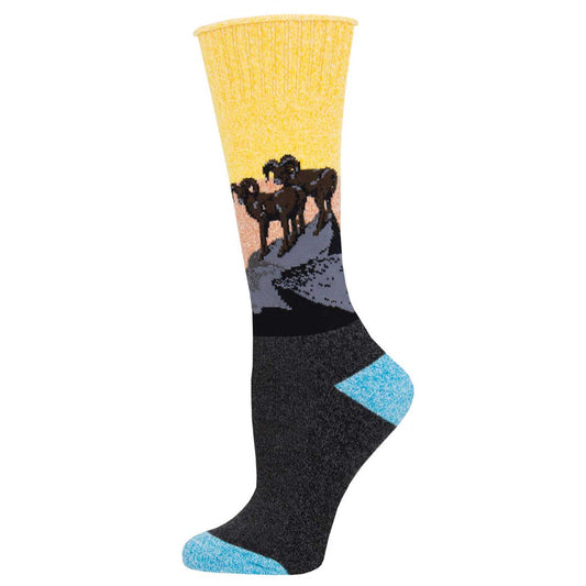 A pair of socks with a graphic design of rams on a mountain against a sunset, transitioning colors from yellow to dark gray with a blue toe cap.