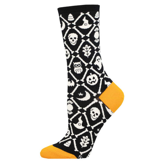 A pair of women's socks with a Halloween-themed pattern including skulls, pumpkins, and ghost shapes in black and white with a yellow orange heel and toe.
