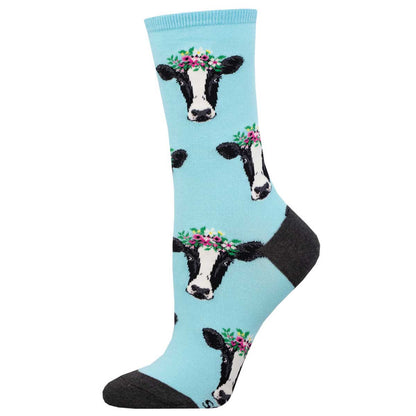 A pair of blue crew socks with a pattern of cow heads wearing flower crowns.