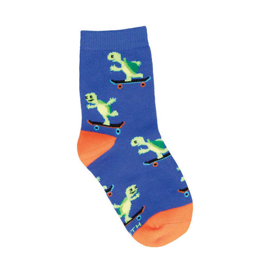 A pair of kids' socks with a blue background featuring green turtles skateboarding and orange accents on the heels and toes.