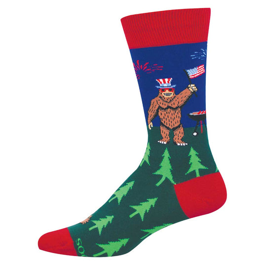 Sock with bigfoot wearing an American flag hat and grilling next to trees on a blue background