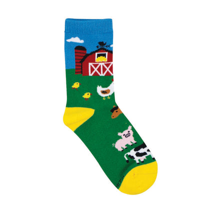 Children's socks with a barnyard scene, featuring cows, pigs, chickens, horses, and a red barn, on a green background with yellow at the heel.