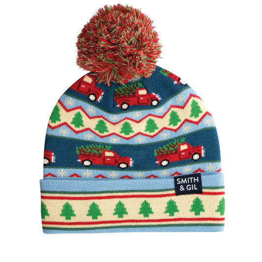 Colorful knit hat with red pom-pom, Christmas tree pattern, and 'Smith & Gil' label on a white background