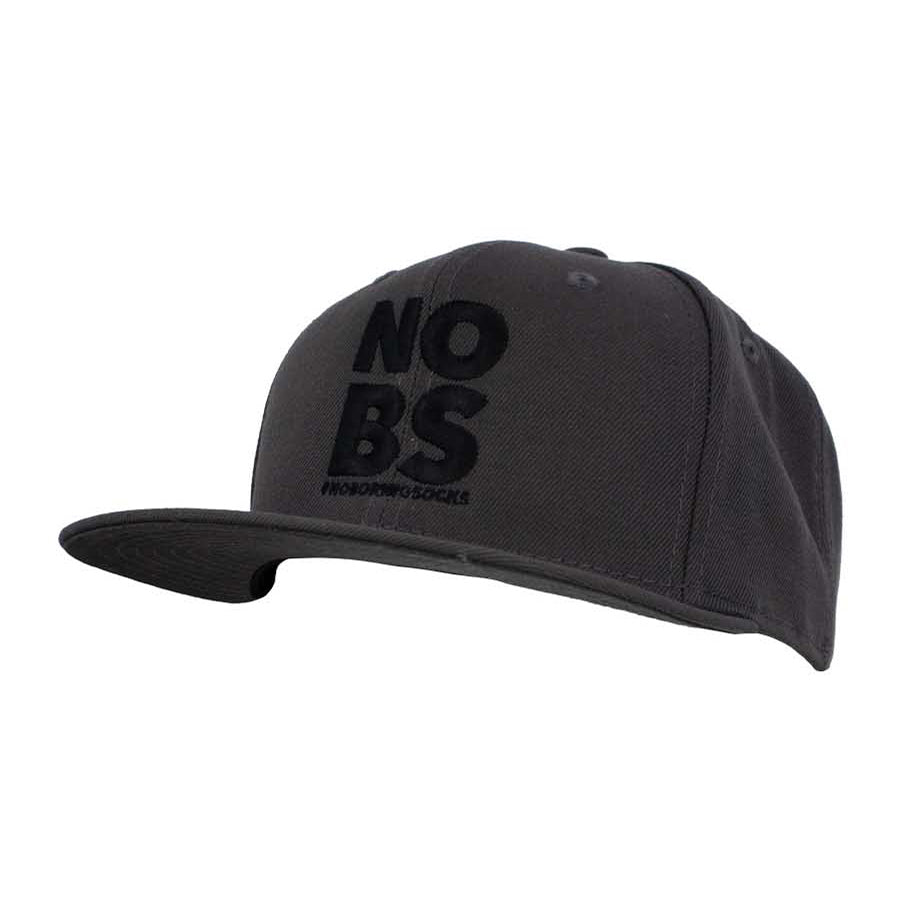 A dark grey flat bill hat with 'NO BS' #NoBoringSocks printed prominently in the center.