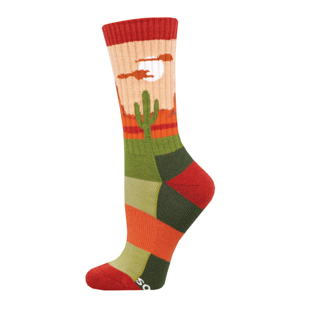 A colorful crew sock with a desert landscape design, featuring a cactus and sunset, predominantly in orange, red, and green shades.
