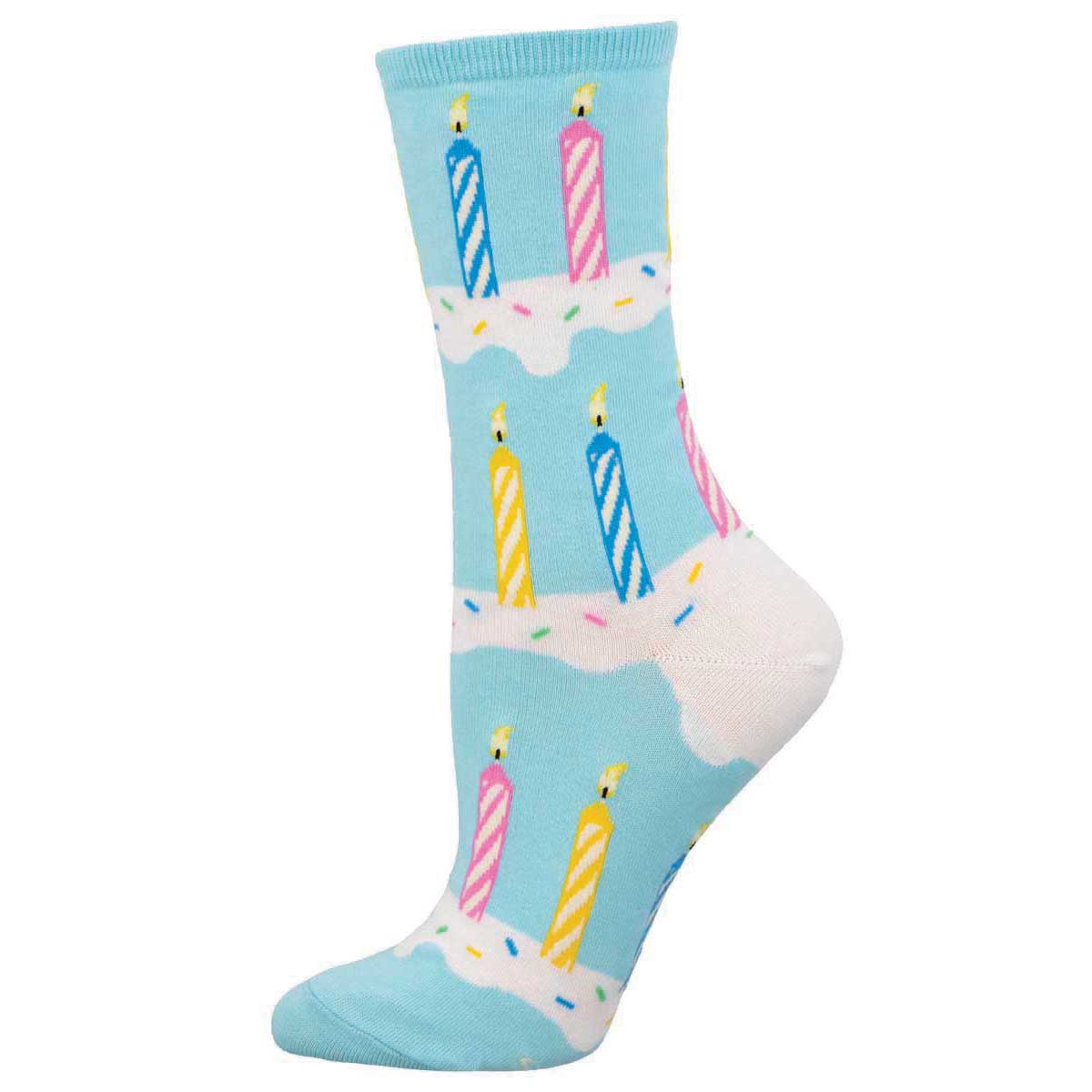 A pair of blue cotton crew socks featuring a pattern of colorful birthday candles on a white icing.