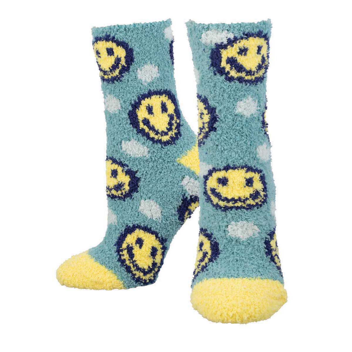 A pair of blue fuzzy crew socks with a happy face emoji pattern and yellow accents on the toes and heels.