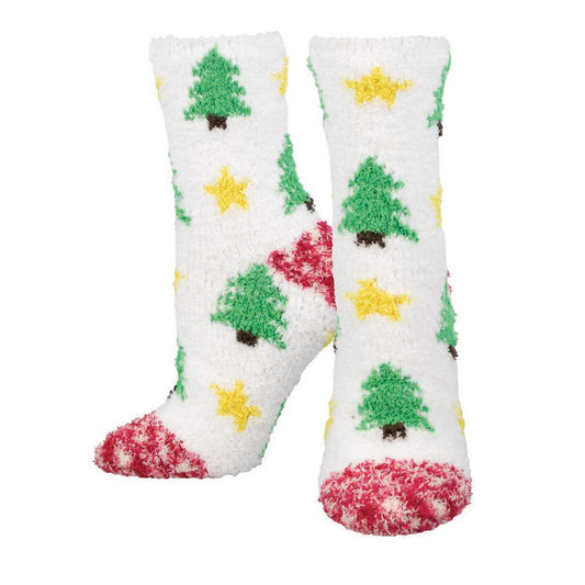 A pair of fuzzy white crew socks with a Christmas tree and star pattern, featuring green trees and yellow stars, with red accents on the toes and heel.