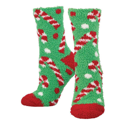 A pair of fuzzy green holiday socks with candy cane patterns and red accents.