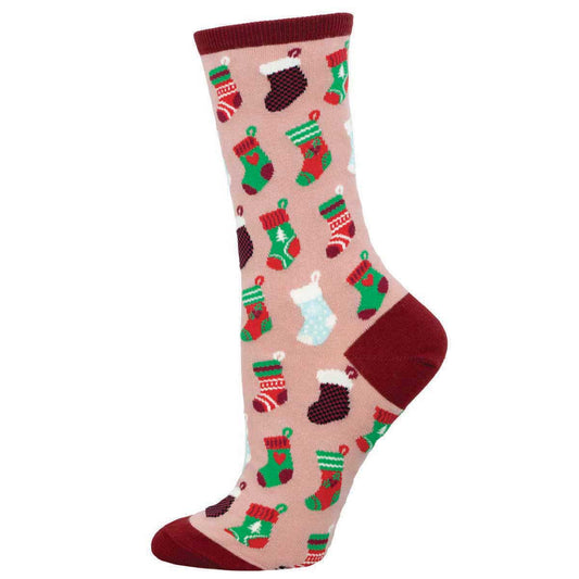 A pair of pink crew socks with a pattern of various holiday-themed images such as stockings and gifts.