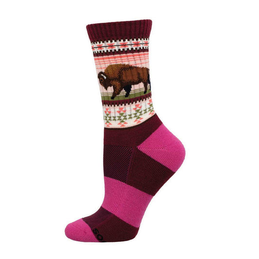 A pair of merino wool socks with a geometric pattern and a bison at the top cuff, predominantly in red and pink colors.