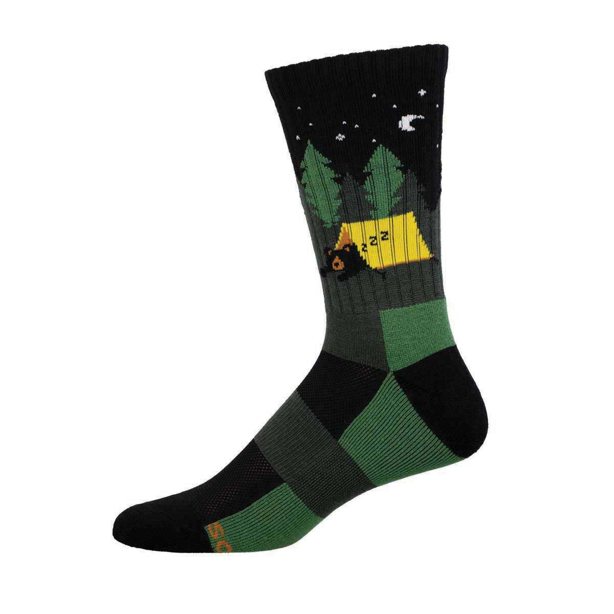 A merino wool sock with a pattern that includes a bear, trees, and a cabin in a night setting, predominantly in black, green, and yellow colors.
