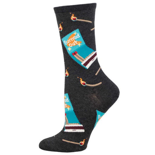 A pair of women's crew socks with a pattern that includes a matchbook and matches design on a charcoal background with the text 'Burned Out'.
